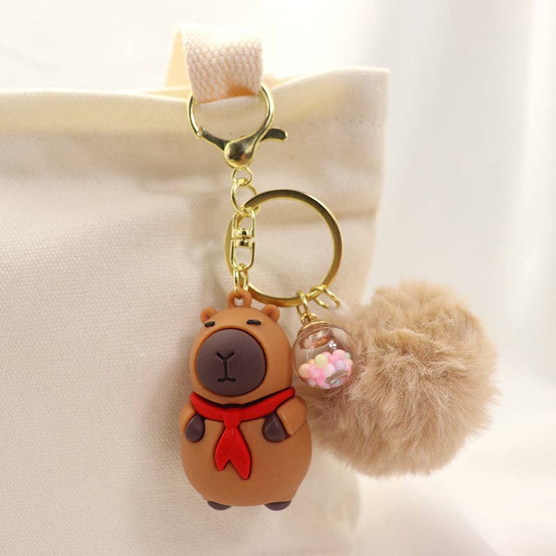 Rosa Capybara Nyckelring Pompom - Kawaii Design med Halsduk/Kamera