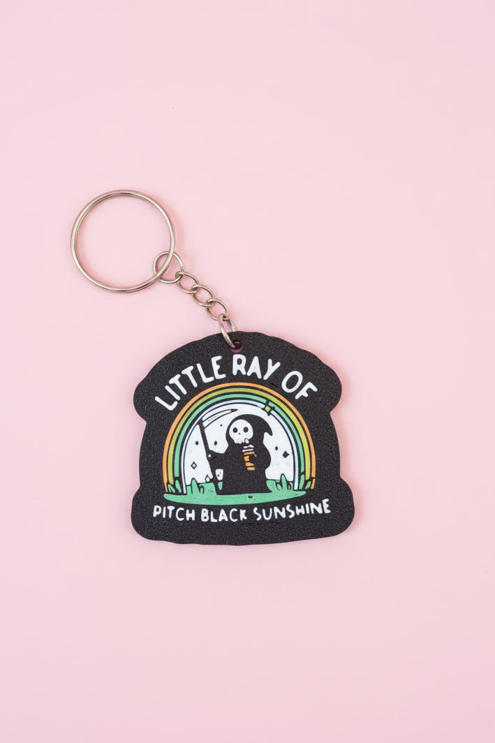 Nyckelring med texten ”Little ray of pitch black sunshine”