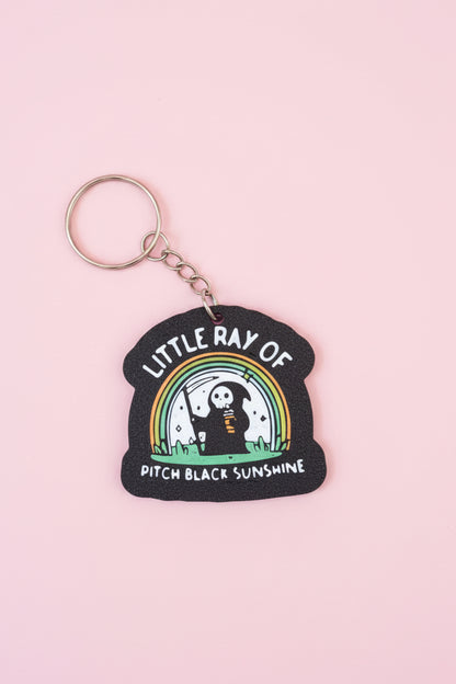 Nyckelring med texten ”Little ray of pitch black sunshine”