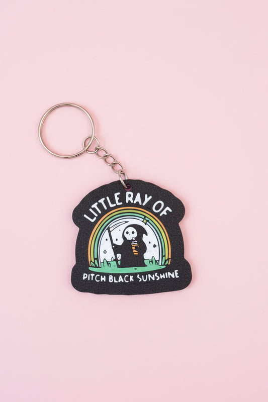 Nyckelring med texten ”Little ray of pitch black sunshine”