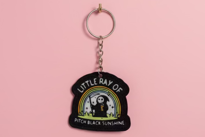 Nyckelring med texten ”Little ray of pitch black sunshine”