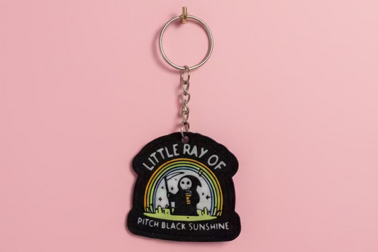 Nyckelring med texten ”Little ray of pitch black sunshine”