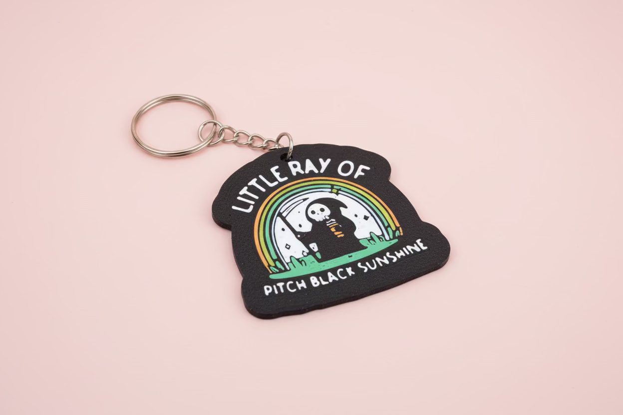 Nyckelring med texten ”Little ray of pitch black sunshine”