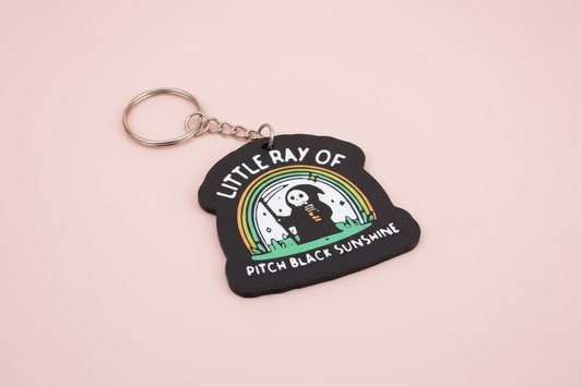 Nyckelring med texten ”Little ray of pitch black sunshine”